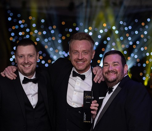 Celebrating in black tie with sparkly background are Queen's Award winners Kevin Jones, Paul Hull and Jamie Warren - owners of KMB Shipping